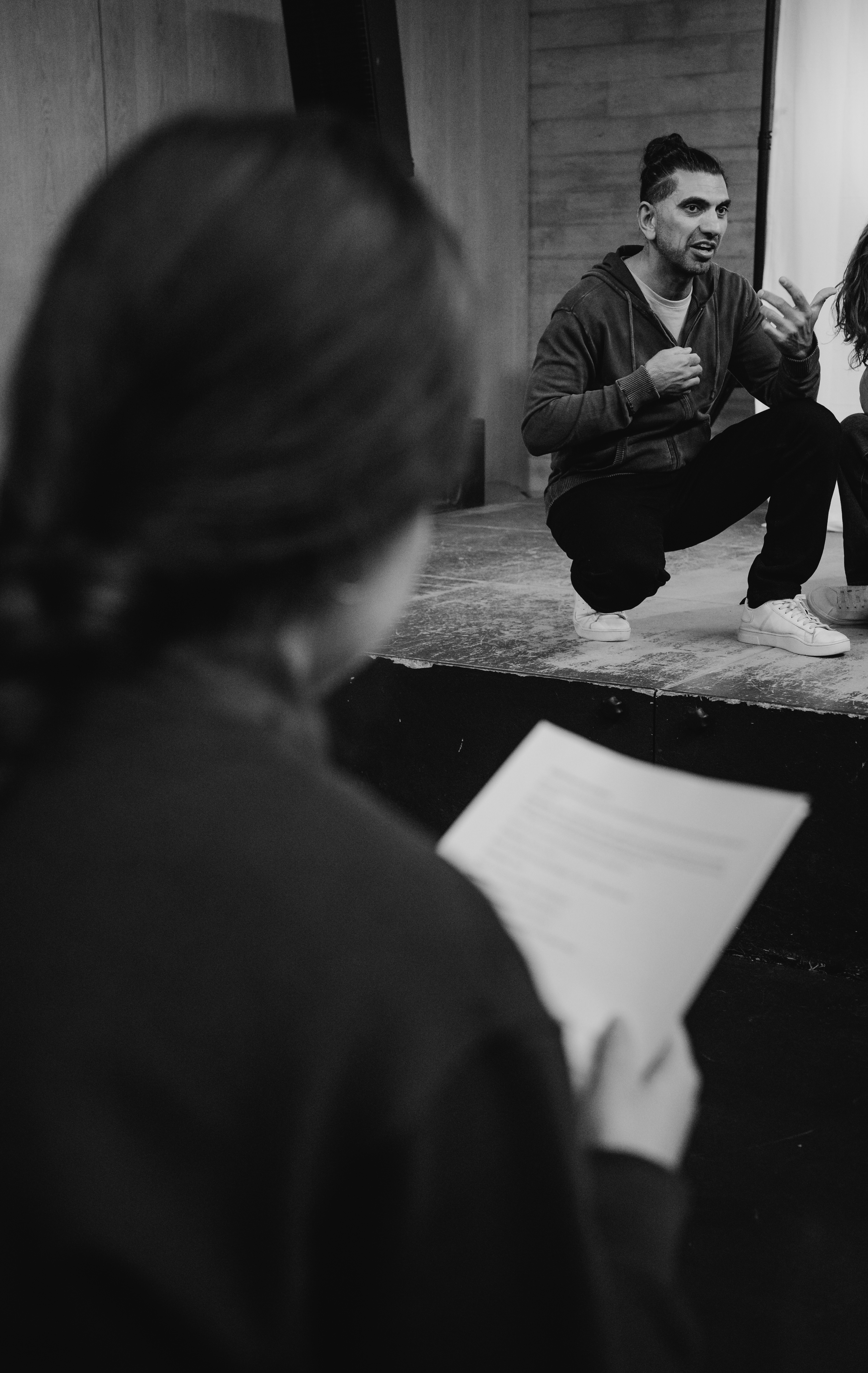 Irfan Taufik (Fotografin: Jennifer Schäufelin) Schwarz-weiß-Fotografie, auf der der Schauspieler Irfan Taufik auf einer Theaterbühne zu sehen ist.